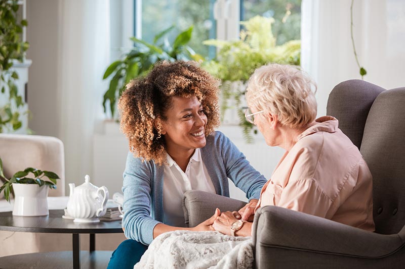 A woman sitting on the couch with an older person.