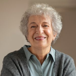 A woman with grey hair smiling for the camera.