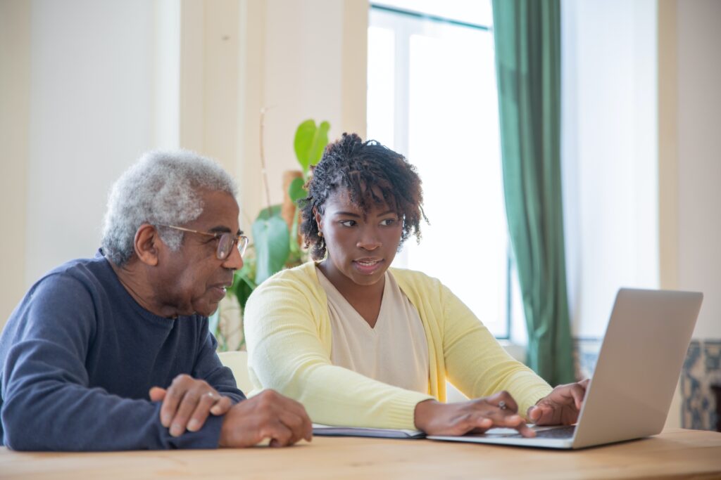 A man and woman looking at a laptop.